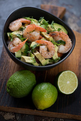 Salad with avocado, cucumber and fried tiger shrimps, selective focus, vertical shot