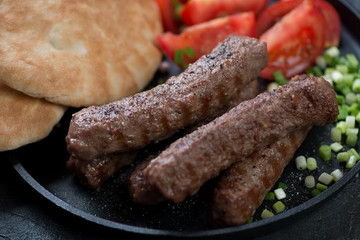 Close-up of grilled cevapcici or skinless beef sausages, traditional dish in the Balkans, horizontal shot