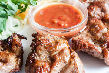 pork shish kebab with tomato sauce on a white plate