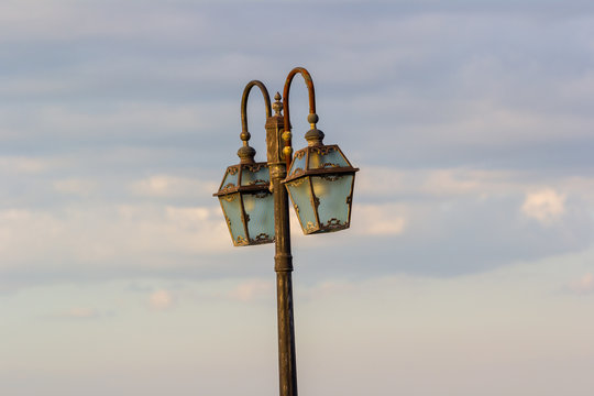 vintage lamp post under cloudy sky