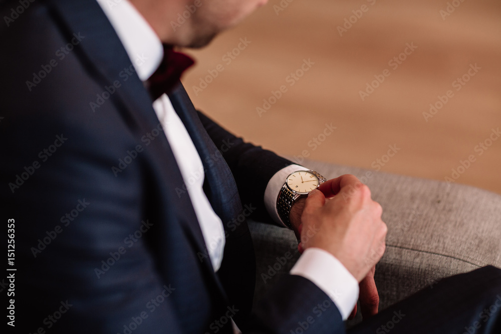 Wall mural watch with white dial on the hand of a man in a white shirt