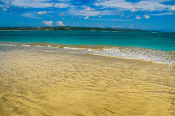 Blue water in ocean, white sand beach.