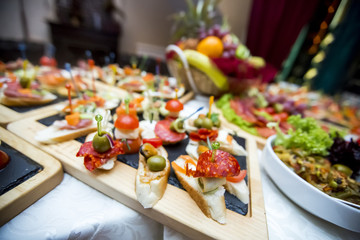 Beautifully decorated catering banquet table with different food snacks and appetizers