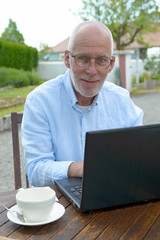 senior man using a laptop outside