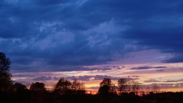 Time lapse video of evening blue clouds on a sunset sky.