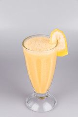 Banana shake with a slice of banana on isolated white background