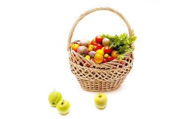 Vegetables in the basket and fruits - plums, tomatoes, apples, parsley - food for vegetarians