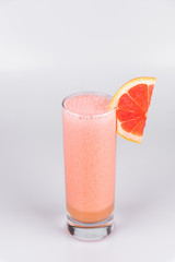 Grapefruit fresh juice with a slice of grapefruit on isolated white background