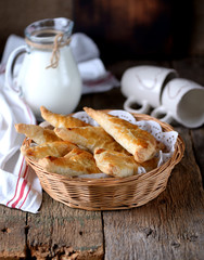 Pies made of puff pastry with meat on an old wooden background. Rustic style.