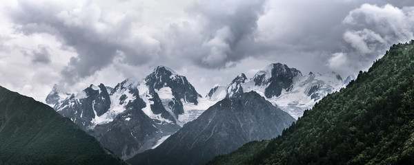 Stormy clouds over the snowy Caucasus mountains. View from Irik gorge, Kabardino-Balkaria, Russia.