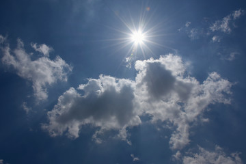 Fototapeta na wymiar 輝く太陽と青空と雲「空想・雲のモンスター」融けだす、眩しい、紫外線などのイメージ