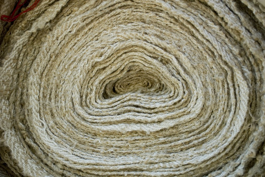 Background: Very long cotton fabric cordura roll creating a kind of spiral, usually used in outdoor environments, for example for garden furniture, color beiges, italy