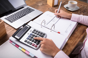 Fototapeta na wymiar Businesswoman Calculating Tax On Desk