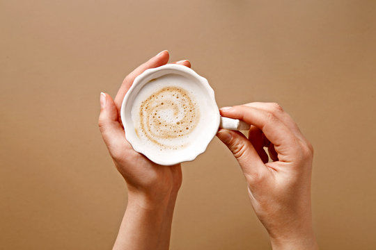 Woman Drinking Coffee. View From Above. Hands Holding A Cup Of Cappuccino. Top View