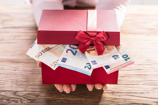 Woman Holding Gift Box Of Us Euro Bills
