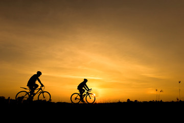 Obraz premium Silhouette of cycling on sunset background