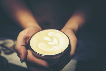 Fototapeta na wymiar Drip coffee latte art, vintage filter image