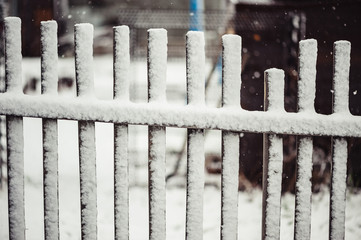 Old wooden fence covered with snow. The broken part.