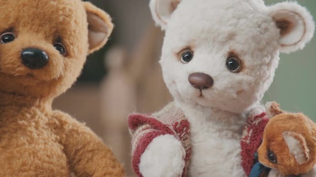 Plush bears handmade: two large teddy bears and two small ones on the table. Collectible soft toy - a teddy bear, as in the 20th century. A toy in vintage style is handmade. Old-fashioned teddy bears