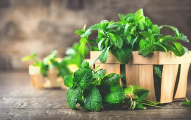 Poster Mint. Bunch of fresh green organic mint leaf on wooden table closeup © Subbotina Anna