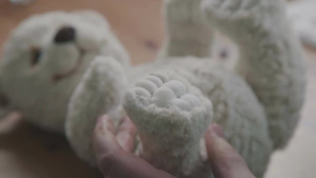 The toy is made in classic style. The process of creating a teddy bear: the master draws a toy paws. Fine brush for drawing: paws of a soft toy. Teddy bear in vintage style