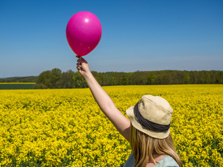 glücklich: Frau hält Ballon in die Luft