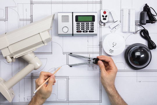 Male Engineer Working On Blueprint With Security Equipments