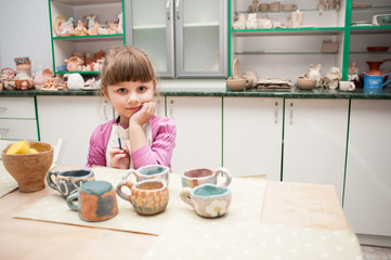 Little girl makes a product of clay