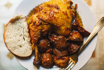 Roasted chicken leg with baked potatoes