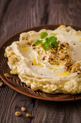 Plate of creamy hummus on wooden table.Ramadan food. Selective focus. Toned image