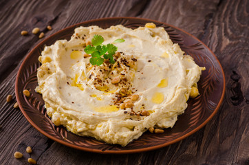 Plate of creamy hummus on wooden table.Ramadan food. Selective focus. Toned image