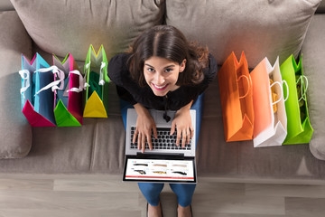 Woman With Shopping Bags Using Laptop