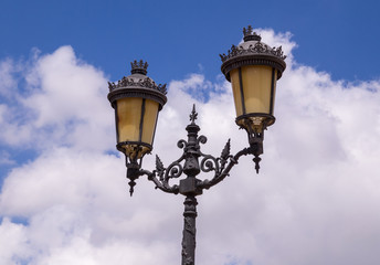Fototapeta na wymiar Old antique street lamp with blue sky with clouds