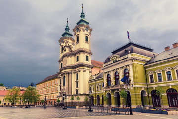 Fototapeta na wymiar Eger main square in Hungary, Europe with dark moody sky and catholic cathedral. Travel outdoor european background