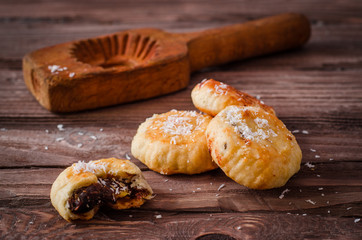 Maamoul or mamoul - arabic cookies stuffed dates with coconut near wooden mold on vintage wooden table background. Selective focus. Toned image