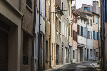 a narrow street with colored houses in small european city
