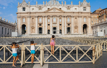 Kids climbing on the fence at the Saint Peter square in Vatican, Italy. 04 September, 2015
