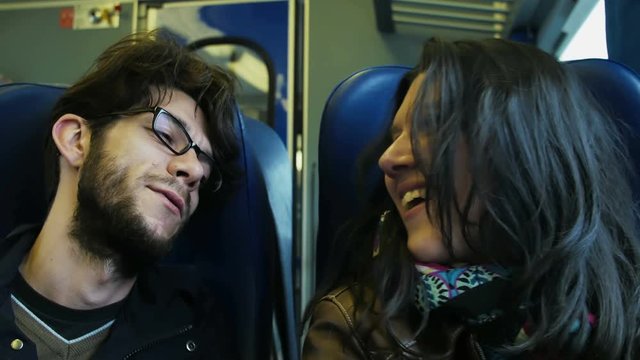Happy young couple traveling by train