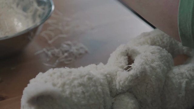 The process of stuffing a soft toy filler. Filler for soft toys. The process of creating a soft handmade toy.Teddy bear as in the 20th century - fashionable collectible toys. Beige teddy bear