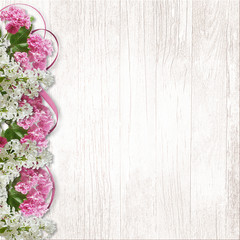 Border of lilac and sakura on a white wooden background