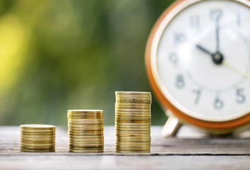 Gold money coins and alarm clock - business success concept