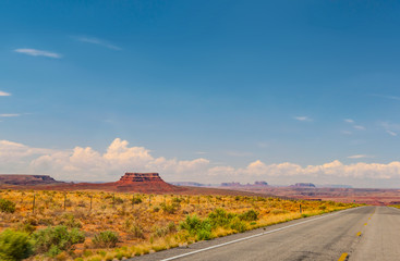Fototapeta na wymiar Desert Road winds through Monument Valley in Southwestern USA