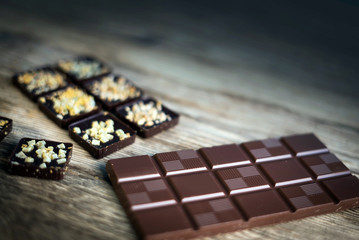 Chocolate bar pieces with cocoa powder. Background with chocolate. Slices of chocolate, Copyspace