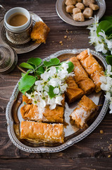 Homemade baklava rolls in iron try on wooden background. Ramadan food. Selective focus