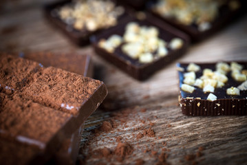 Chocolate bar pieces with cocoa powder.  Background with chocolate. Slices of chocolate,  Copyspace