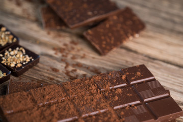 Chocolate bar pieces with cocoa powder.  Background with chocolate. Slices of chocolate,  Copyspace