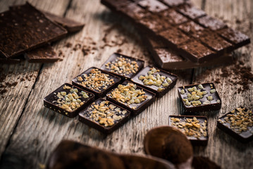 Chocolate bar pieces with cocoa powder.  Background with chocolate. Slices of chocolate,  Copyspace