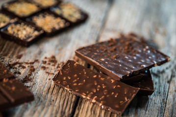 Chocolate bar pieces with cocoa powder.  Background with chocolate. Slices of chocolate,  Copyspace