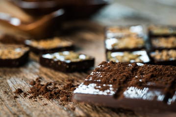 Chocolate bar pieces with cocoa powder.  Background with chocolate. Slices of chocolate,  Copyspace
