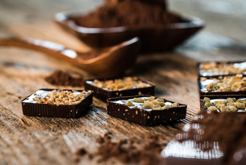 Chocolate bar pieces with cocoa powder.  Background with chocolate. Slices of chocolate,  Copyspace